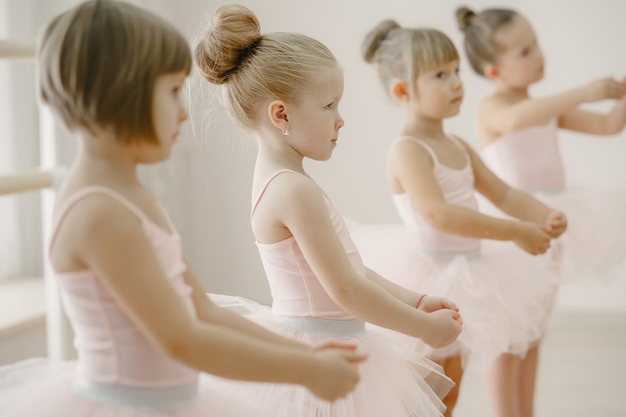 Mastering the First Impression: Your intriguing post title goes here Four young girls in ballet class wearing pink tutus, practicing together.